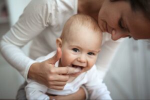 Woman wipes baby’s gum